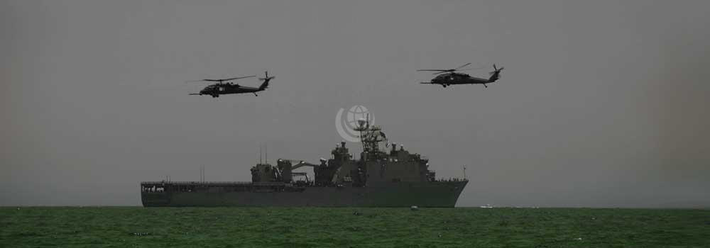 Naval ship at sea with two helicopters flying above