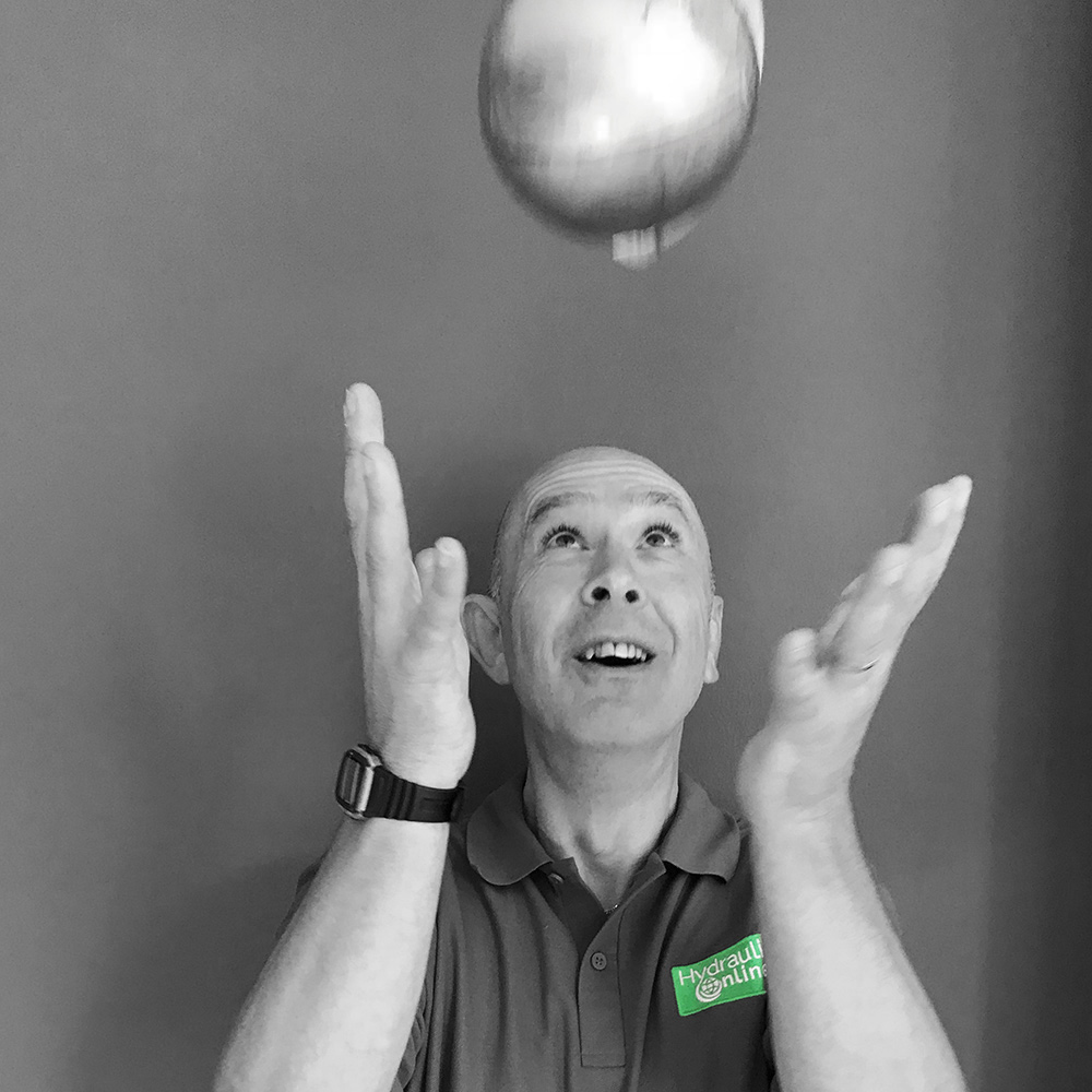 Steve, Technical Sales Engineer Steve Hydraulics Online throwing globe up in the air